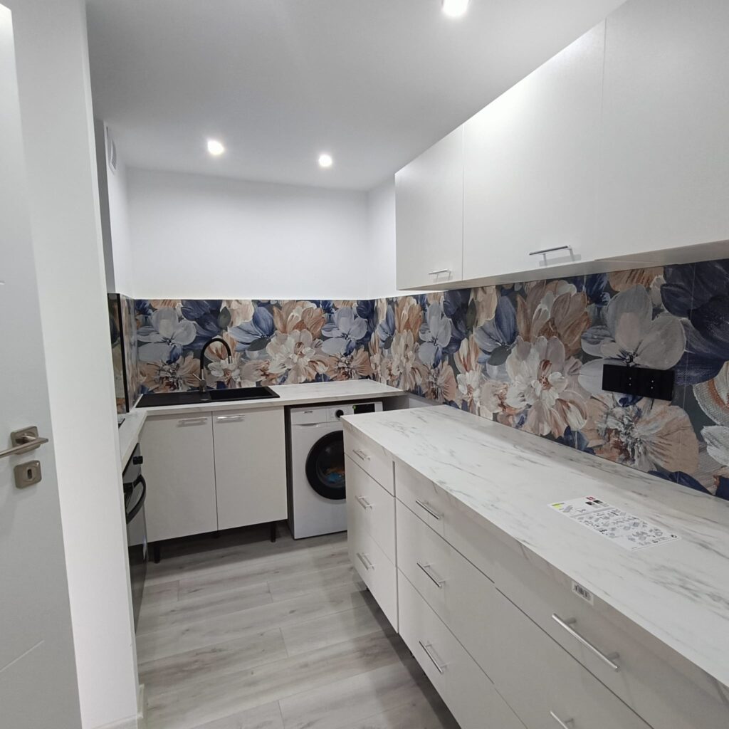 Nowoczesna biała kuchnia z artystycznym panelem ściennym w kwiaty