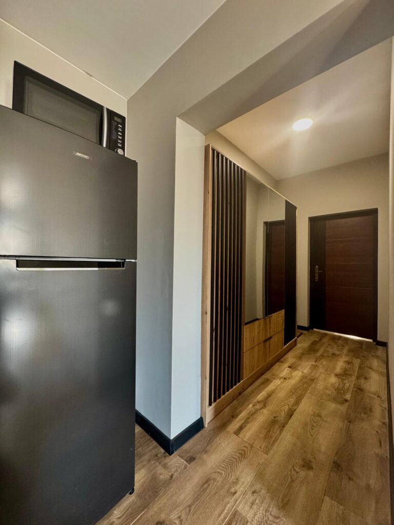 Przedpokój z jasną podłogą oraz ciemnymi dodatkami